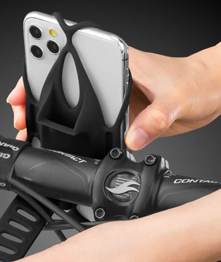 Telefon wird in die Gummibänder von Bone Bike Tie am Vorbau eingesetzt