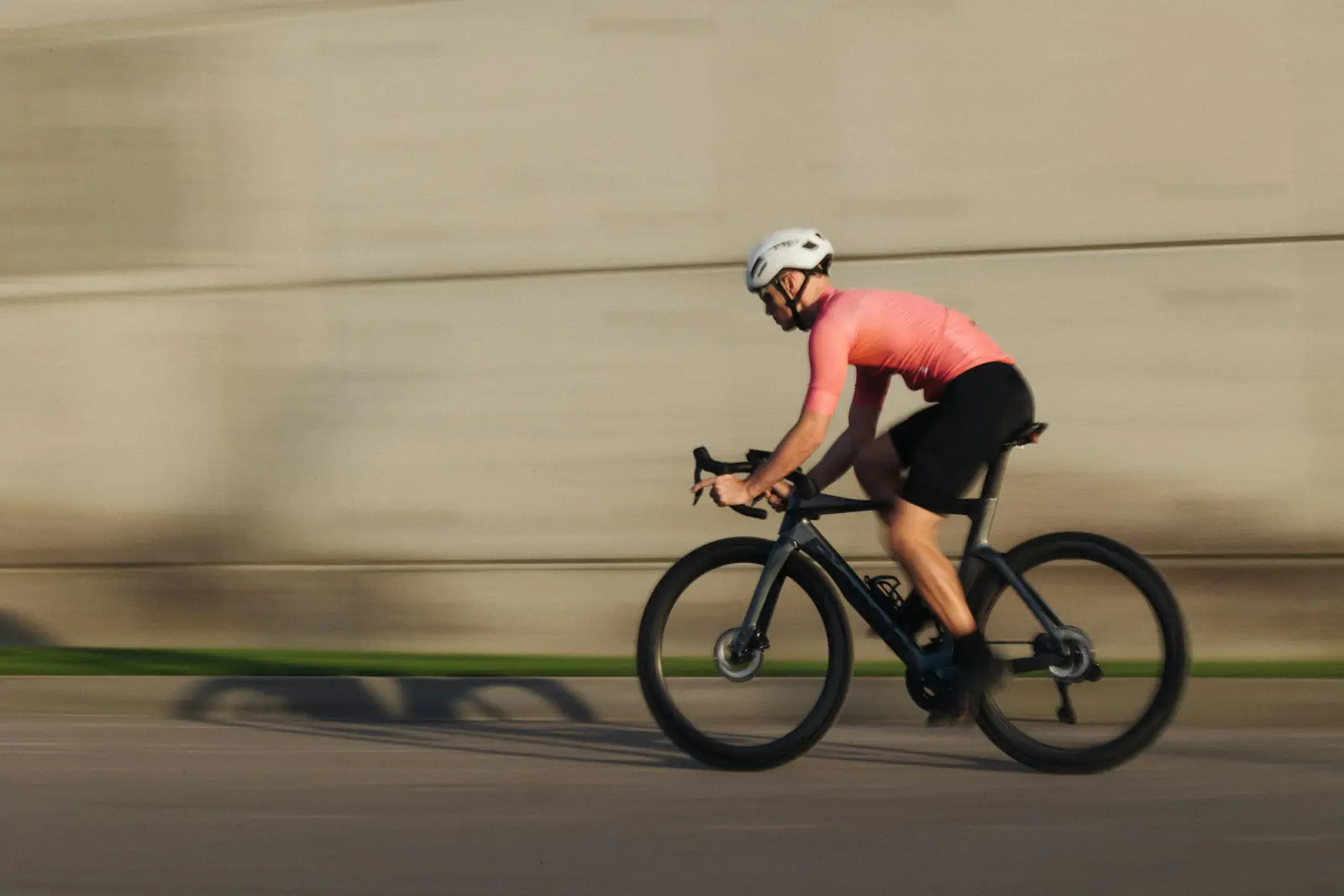 Rennradfahrer in gleichmäßigem Tempo, Hintergrund durch die Geschwindigkeit verwischt