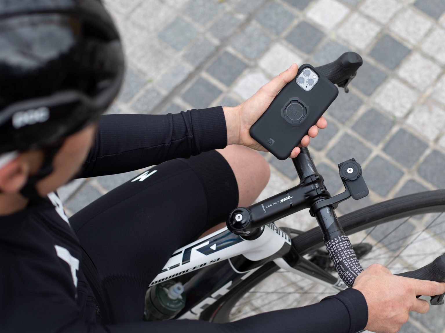 Telefon in einer Quad-Lock-Hülle mit rundem Anschluss, daneben die Halterung am Vorbau