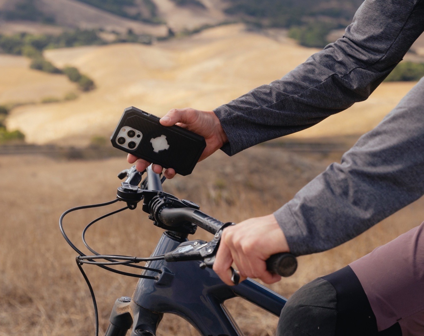 Telefon in einer Rokform-Hülle wird von der Halterung am Vorbau eines Mountainbikes genommen